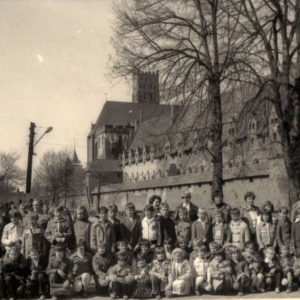 107. Grupa uczniów klas I-IV na tle zamku w Malborku z nauczycielami i matkami, w roku szkolnym 1979/80.